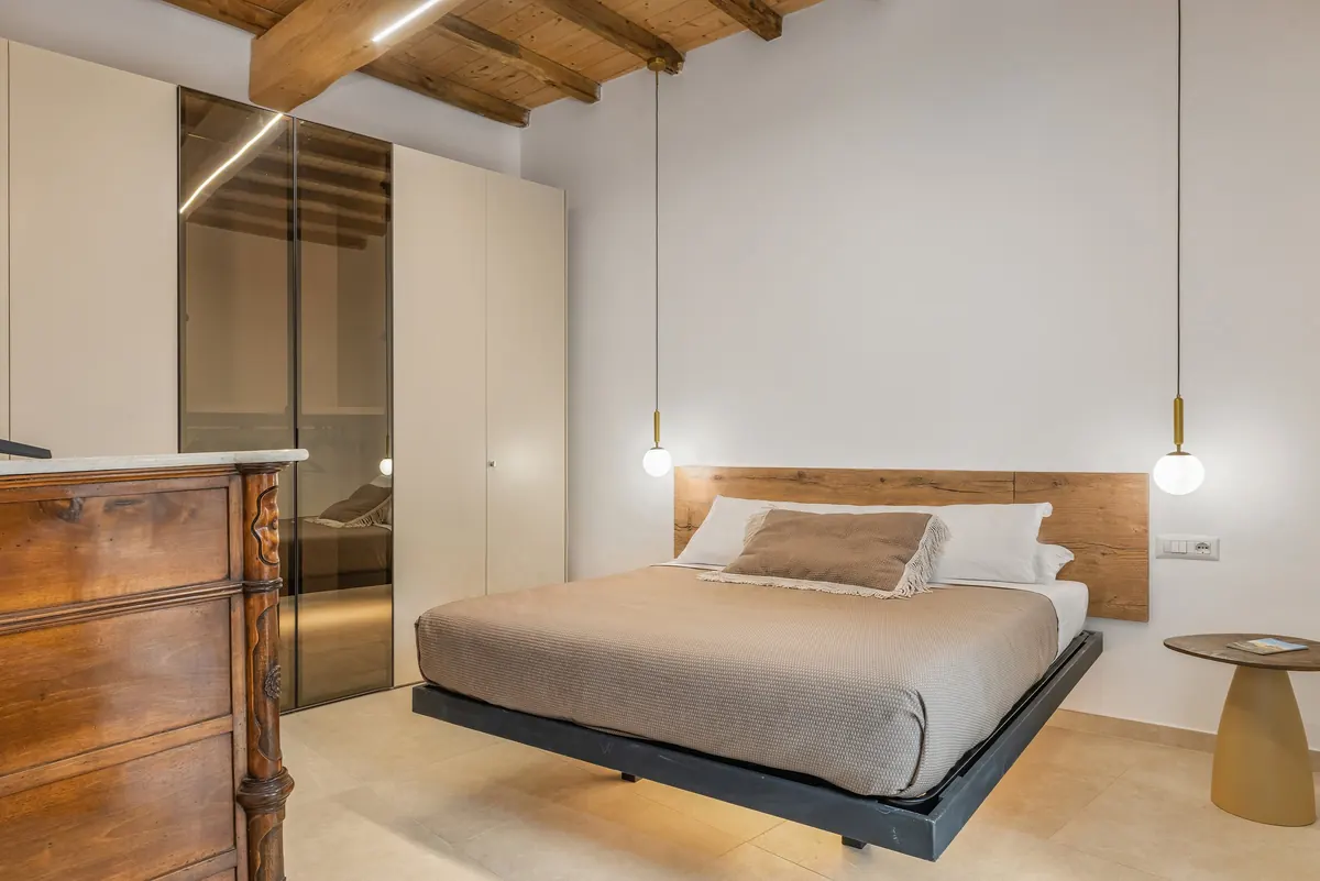 La camera di Rocca Retreat: letto matrimoniale sospeso, testiera in legno e soffitto a travi